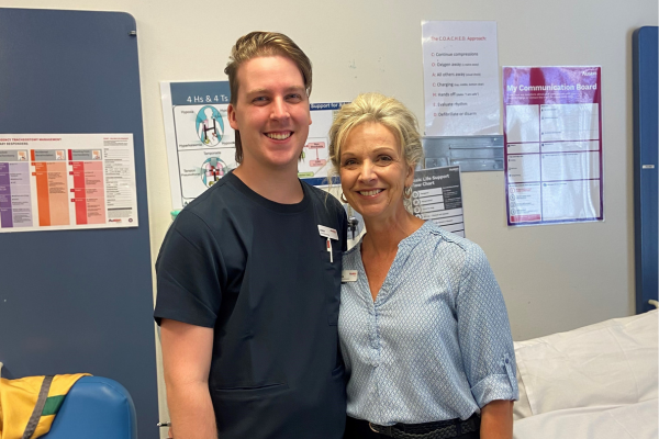 Graduate Nurse, Jordan, in nursing scrubs standing side by side with his mum Saskia, both smiling